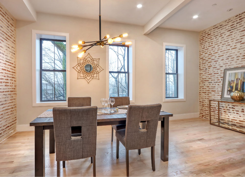 Dining room with white brick accent walls and light wood floors