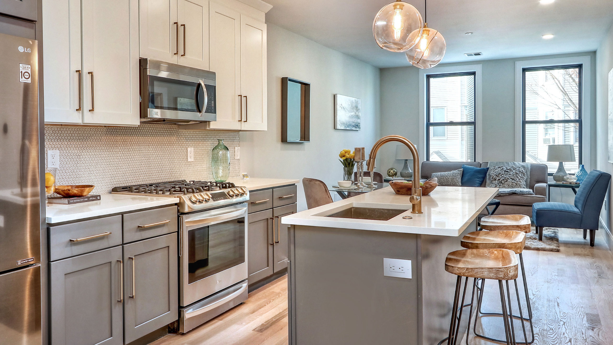 Kitchen with island and wooden barstools next to living area